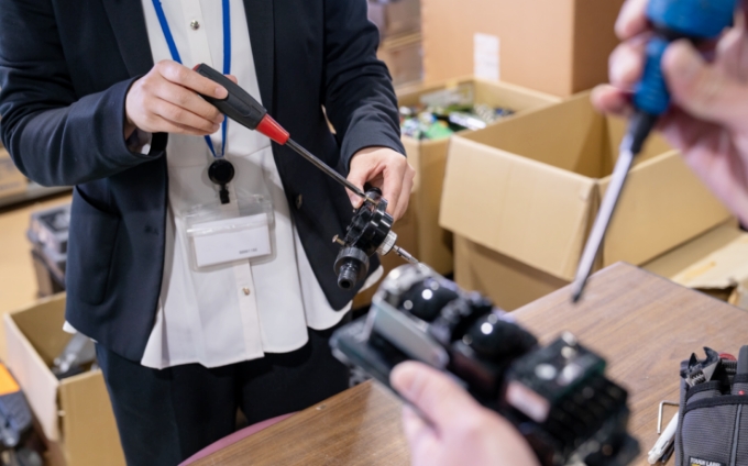 ドライバーを使って分解を行う従業員たち